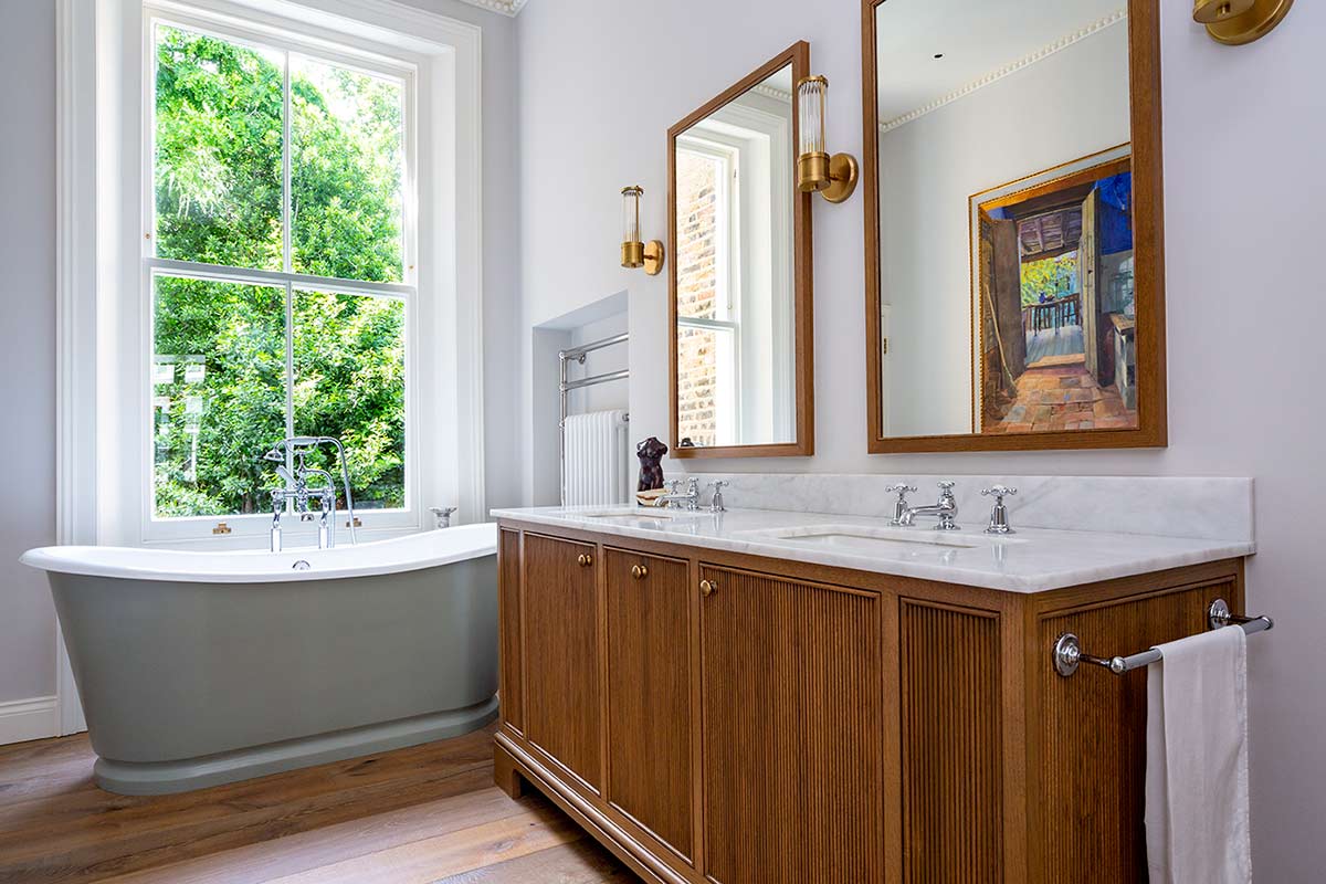 Freestanding bathtub with wooden cupboards