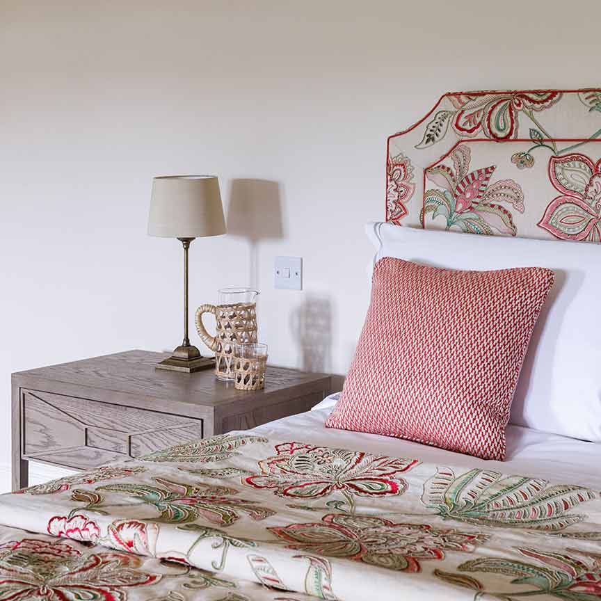 closeup of red cushion on floral themed bed